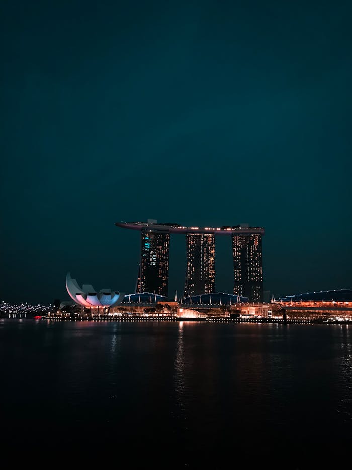 Illuminated Marina Bay Sands reflecting on the water at night, showcasing Singapore's iconic skyline.